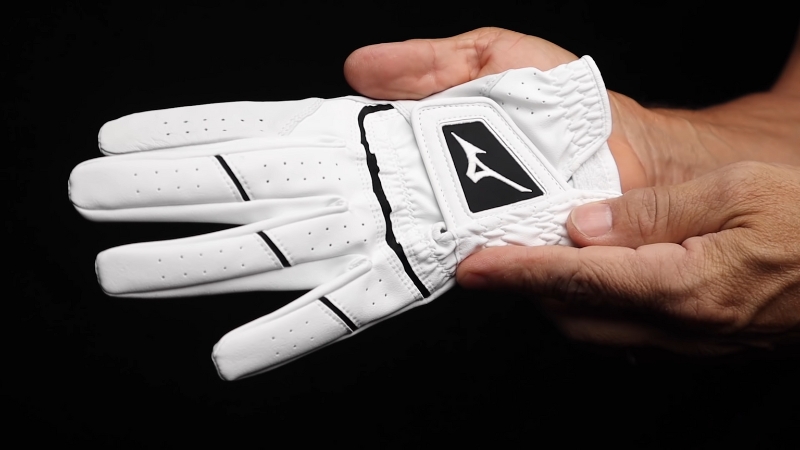 Mizuno Elite Golf Glove, White with Black Accents, Held in Hand Showing the Detailed Design and Logo